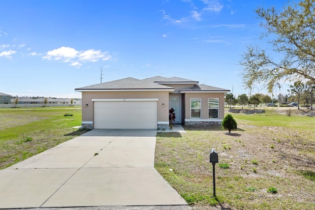 prairie-style house with a front yard, driveway, an attached garage, and stucco siding