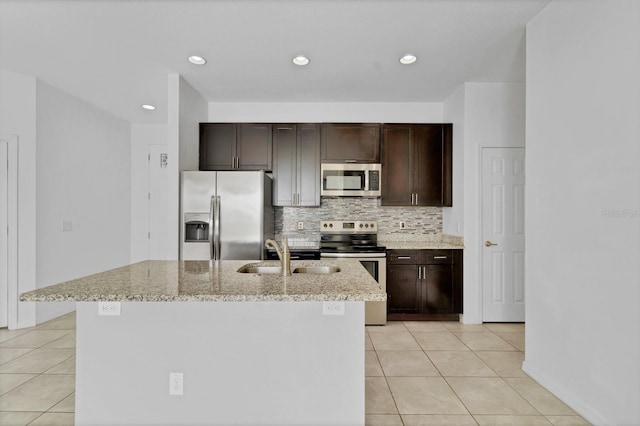 kitchen featuring stainless steel appliances, backsplash, light tile patterned flooring, a sink, and dark brown cabinetry