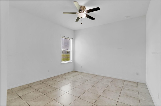 unfurnished room with a ceiling fan and baseboards