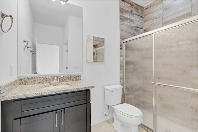 full bath with toilet, a shower stall, vanity, baseboards, and tile patterned floors