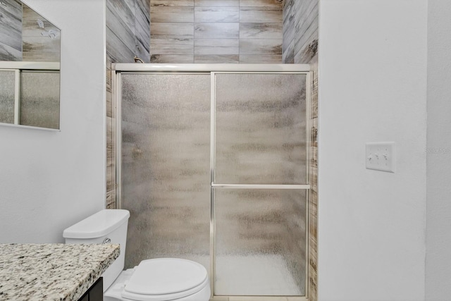 full bath featuring toilet, a stall shower, and vanity