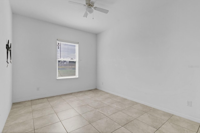 spare room featuring ceiling fan and baseboards