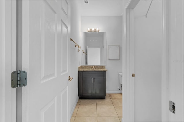 bathroom featuring tile patterned flooring, vanity, and toilet