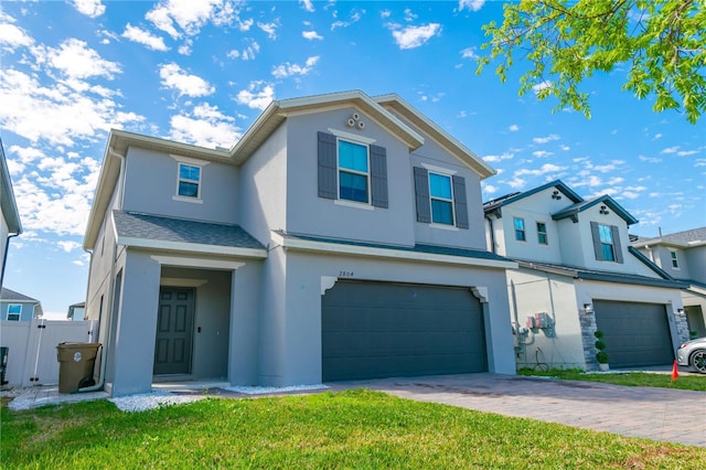 view of front of house with a garage, a shingled roof, decorative driveway, stucco siding, and a front yard