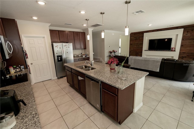 kitchen with stainless steel appliances, visible vents, ornamental molding, a sink, and light stone countertops