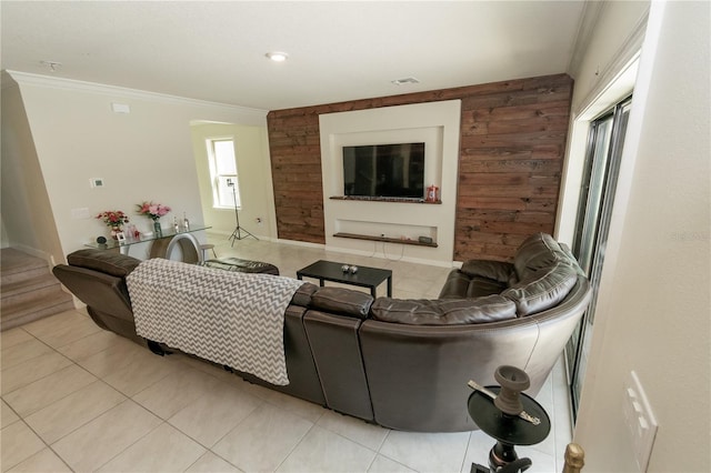 living room with light tile patterned floors, ornamental molding, wood walls, and visible vents