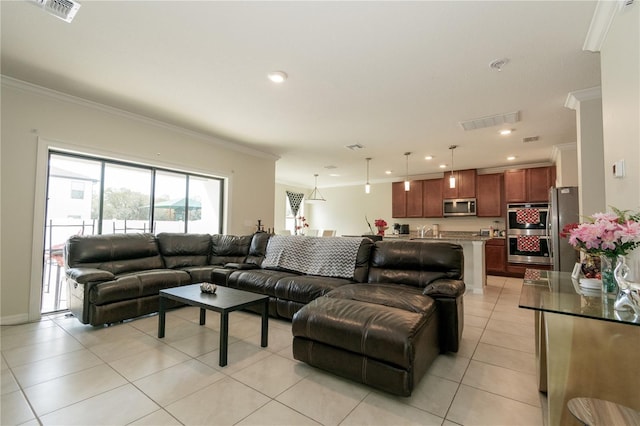 living room with light tile patterned floors, ornamental molding, visible vents, and recessed lighting