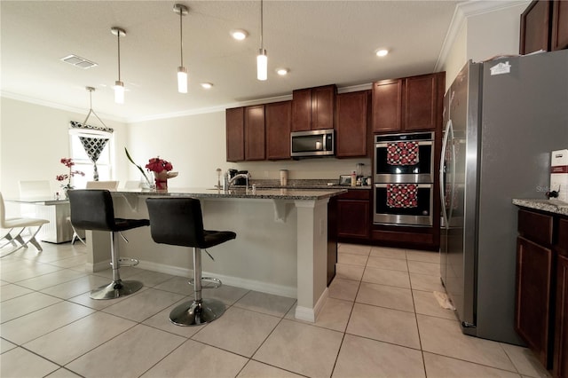 kitchen with light tile patterned floors, visible vents, a kitchen breakfast bar, appliances with stainless steel finishes, and ornamental molding