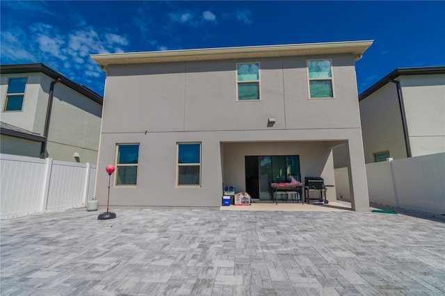 back of property featuring a patio area, fence, and stucco siding