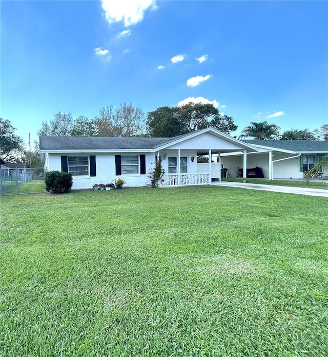 ranch-style home with driveway, an attached carport, a front yard, and fence