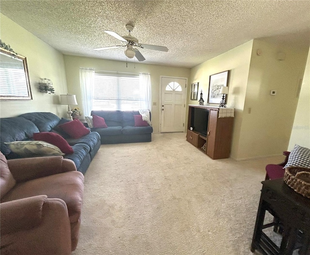 living area featuring light carpet, ceiling fan, baseboards, and a textured ceiling