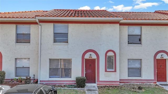 multi unit property with a tiled roof and stucco siding