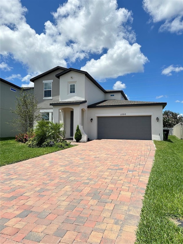 view of front of home featuring a garage, decorative driveway, and stucco siding