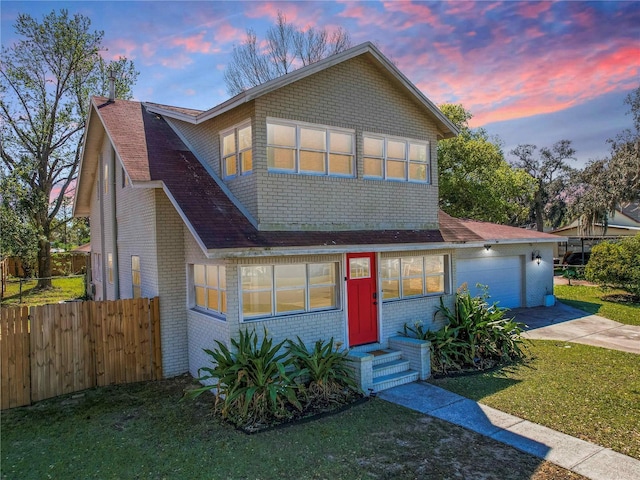 view of front of home featuring a garage, brick siding, fence, driveway, and a lawn