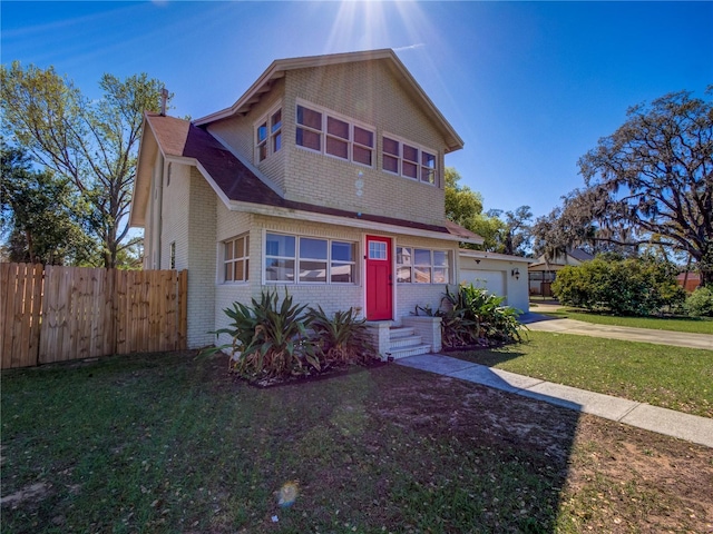 traditional-style home with brick siding, concrete driveway, an attached garage, fence, and a front lawn