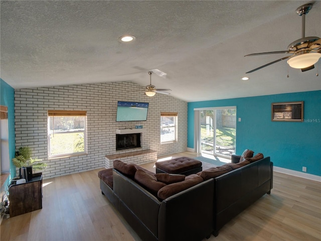 living room with a textured ceiling, ceiling fan, and wood finished floors