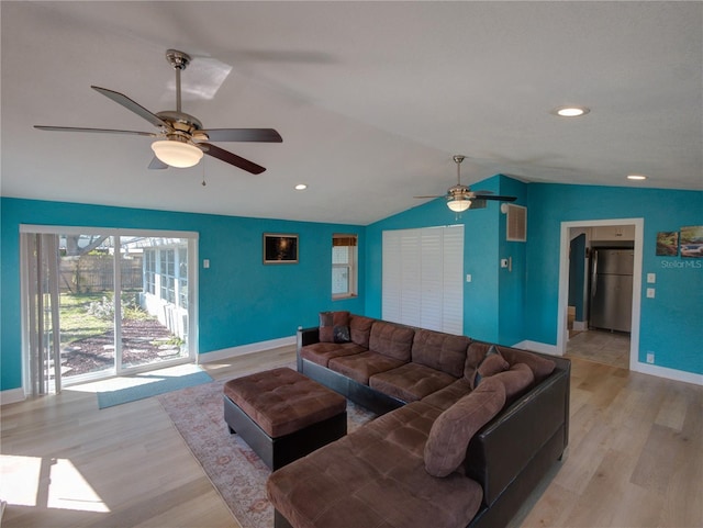 living room with lofted ceiling, ceiling fan, baseboards, and light wood-style floors