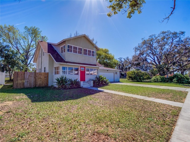 traditional-style home with a garage, driveway, a front lawn, and fence