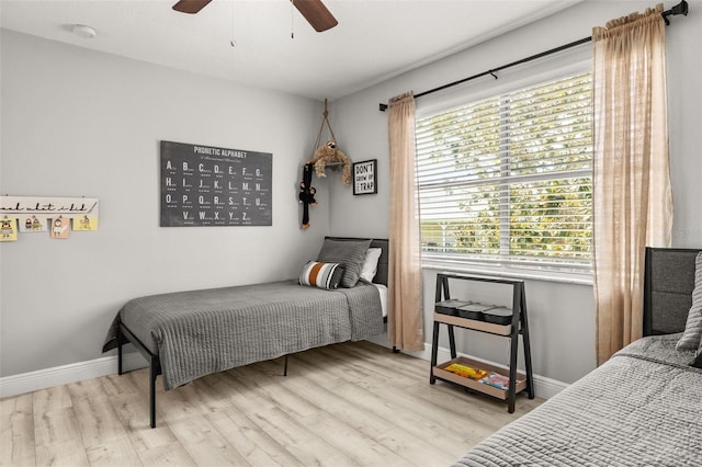 bedroom with baseboards, a ceiling fan, and wood finished floors