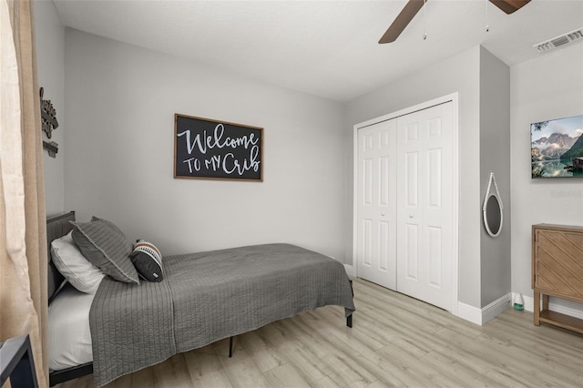 bedroom featuring baseboards, visible vents, ceiling fan, wood finished floors, and a closet