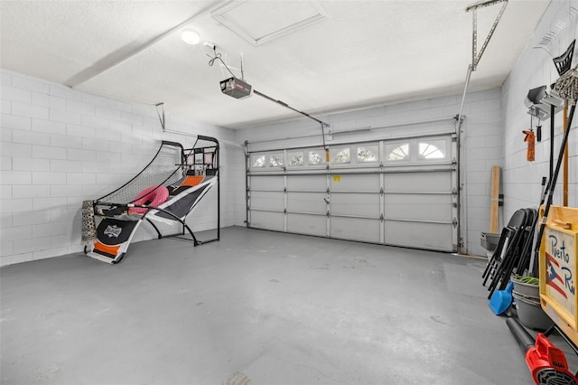 garage with concrete block wall and a garage door opener