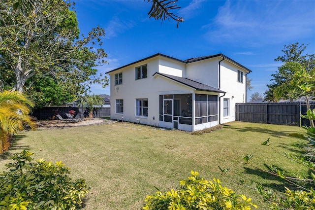 rear view of house featuring a yard, a patio, stucco siding, a sunroom, and a fenced backyard