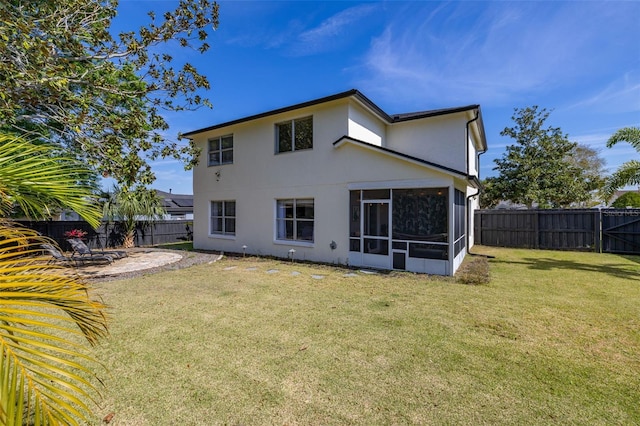 back of house with a sunroom, a fenced backyard, a lawn, and stucco siding