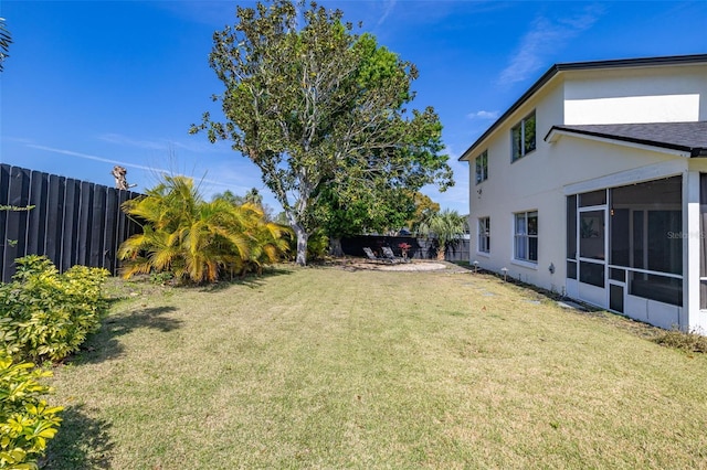 view of yard featuring a sunroom and a fenced backyard