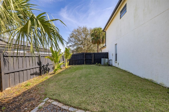 view of yard with a fenced backyard and central AC unit