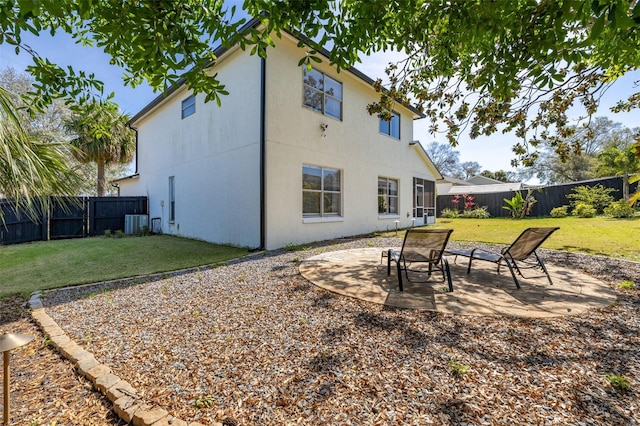 back of house featuring a lawn, a patio area, and a fenced backyard