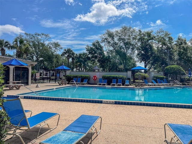 community pool featuring fence and a patio