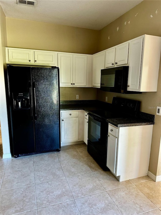 kitchen featuring black appliances, dark countertops, light tile patterned flooring, and white cabinets