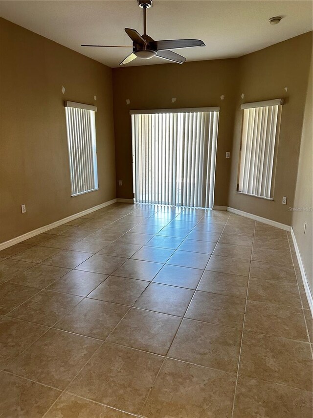 spare room featuring a ceiling fan, plenty of natural light, and tile patterned floors