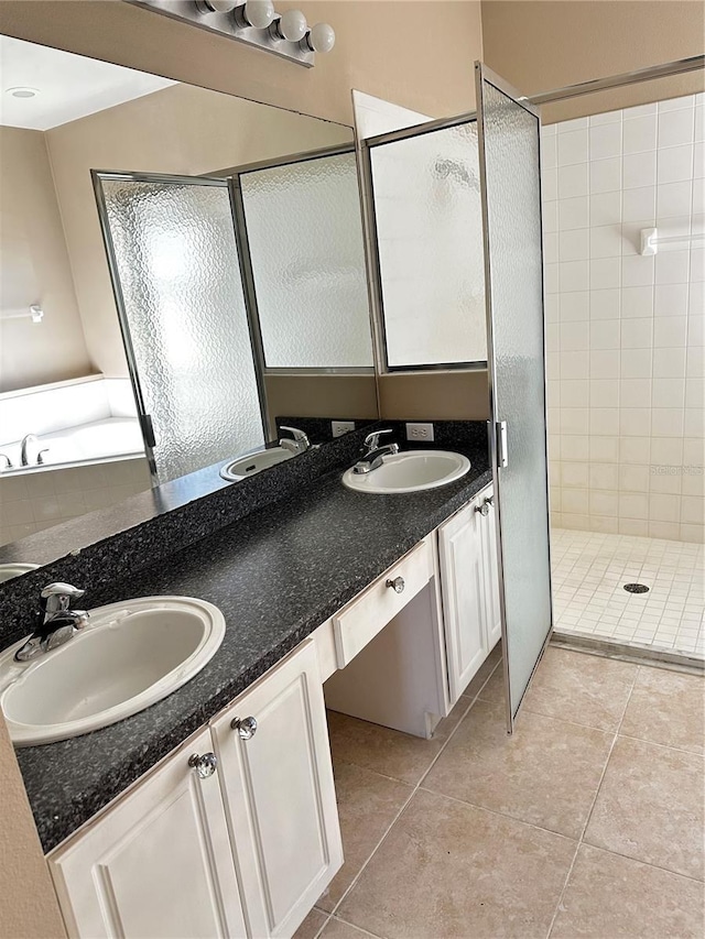 full bathroom with a stall shower, a sink, and tile patterned floors