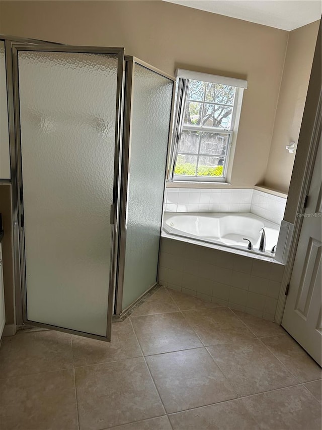 bathroom with a stall shower, tile patterned flooring, and a bath