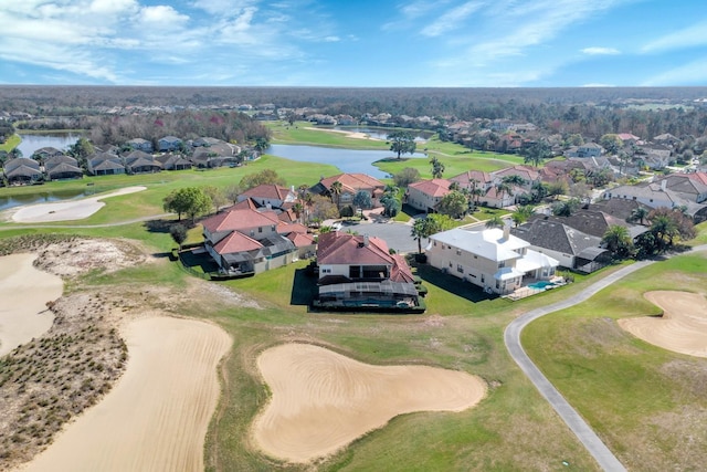 birds eye view of property with view of golf course, a water view, and a residential view