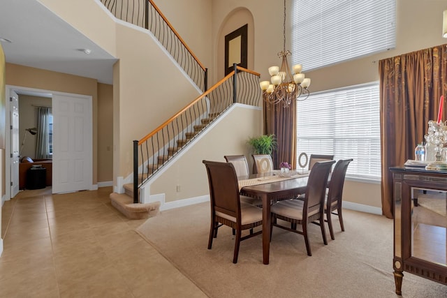 dining space featuring light tile patterned floors, baseboards, stairway, a high ceiling, and a chandelier