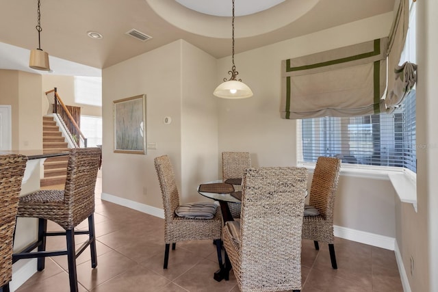 dining space featuring stairway, tile patterned flooring, visible vents, and baseboards