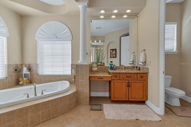 bathroom featuring toilet, vanity, a bath, tile patterned floors, and decorative columns