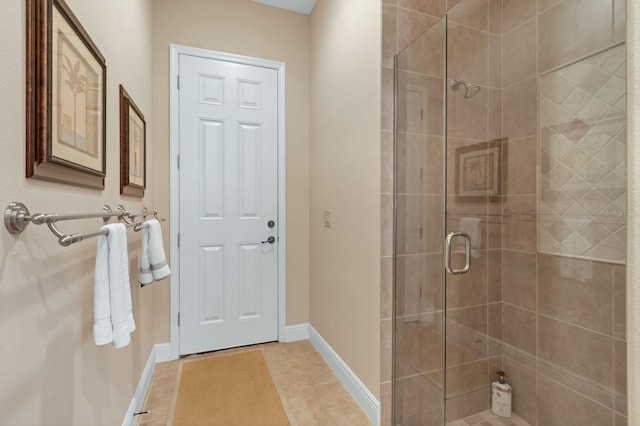 bathroom with a stall shower, baseboards, and tile patterned floors