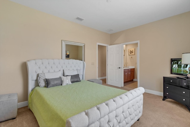 bedroom featuring visible vents, light carpet, baseboards, and ensuite bathroom