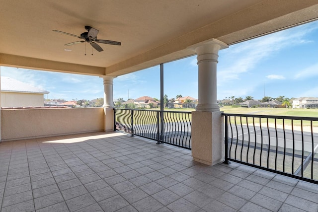 view of patio featuring a balcony, ceiling fan, and a residential view