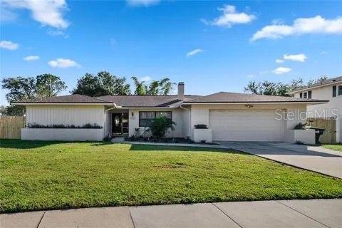 ranch-style home featuring a garage, driveway, and a front yard