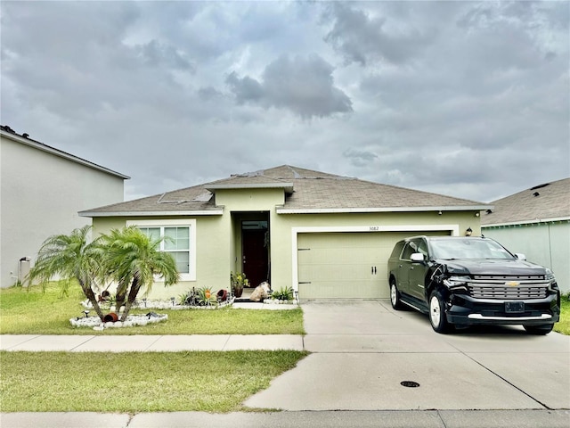 view of front facade with a front lawn, concrete driveway, roof with shingles, stucco siding, and a garage