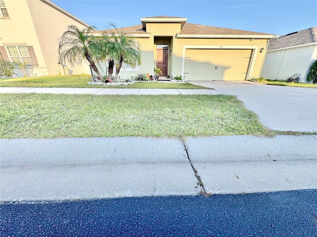 view of front of property with a garage, a front lawn, driveway, and stucco siding