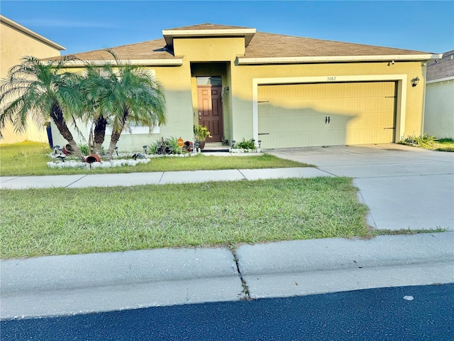 view of front of property featuring stucco siding, an attached garage, driveway, and a front lawn