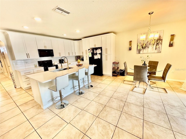 3082 Royal Tern Dr, Winter Haven, FL 33881 - kitchen with black appliances, recessed lighting, light tile patterned floors, a chandelier, and light countertops