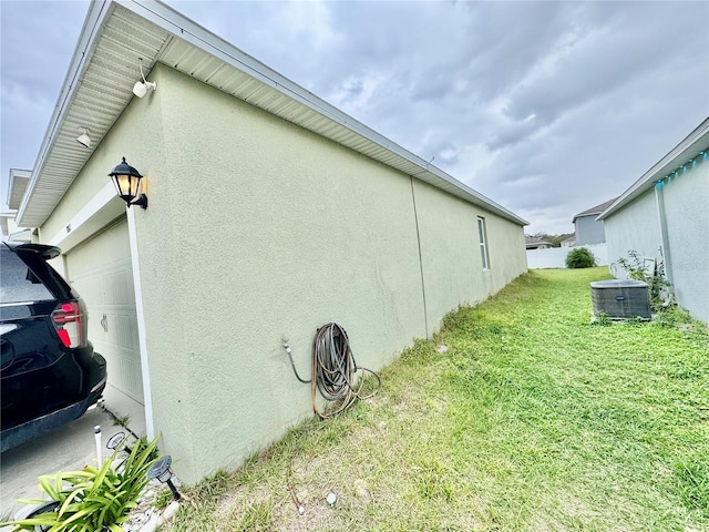 3082 Royal Tern Dr, Winter Haven, FL 33881 - view of side of property with stucco siding, a garage, and a yard