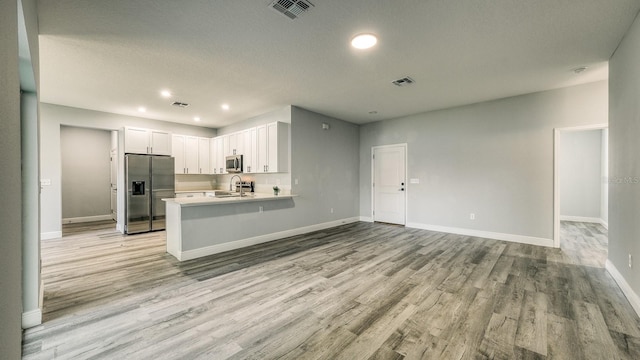 kitchen with visible vents, appliances with stainless steel finishes, light countertops, white cabinetry, and a sink