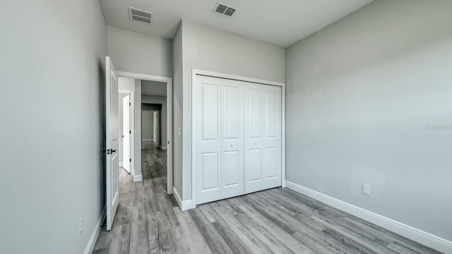 unfurnished bedroom with visible vents, baseboards, and wood finished floors